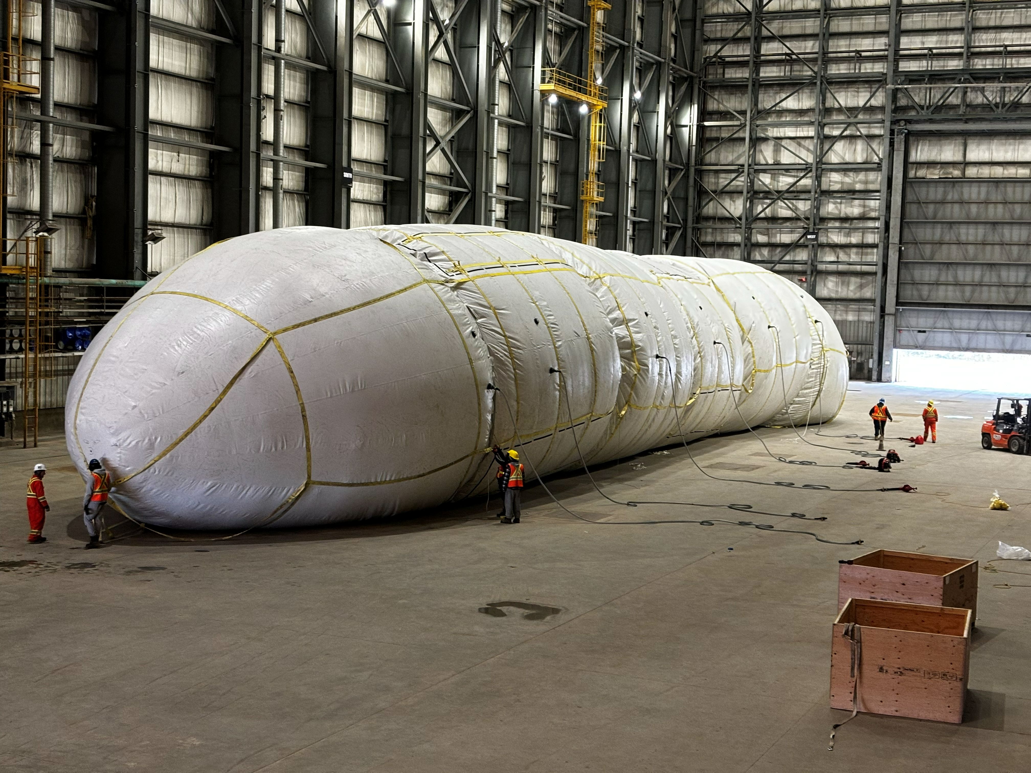 Full-scale AquaLogic vessel undergoing fabrication inside a large industrial facility